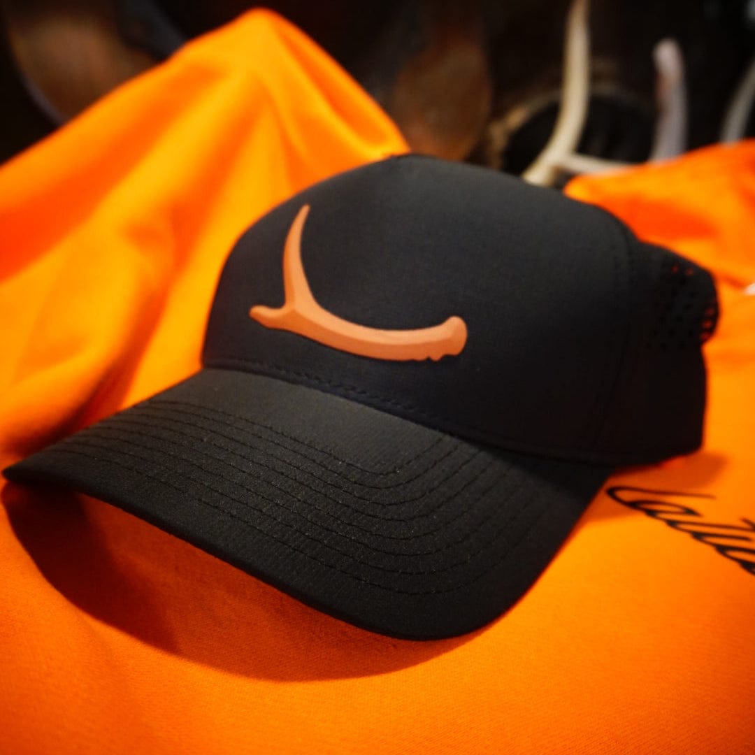 Black cap with orange logo on an orange shirt